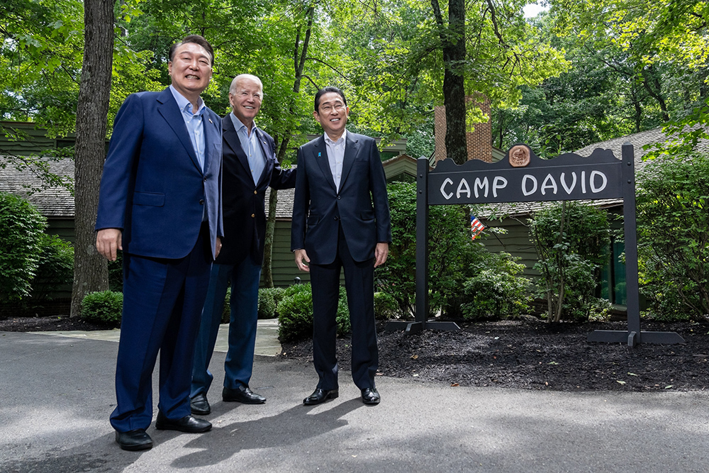 President Joe Biden greets South Korean president Yoon Suk Yeol (left) and Japanese prime minister Fumio Kishida (right) during the Camp David Trilateral Summit on August 23, 2023. Credit: Official White House Photo by Erin Scott