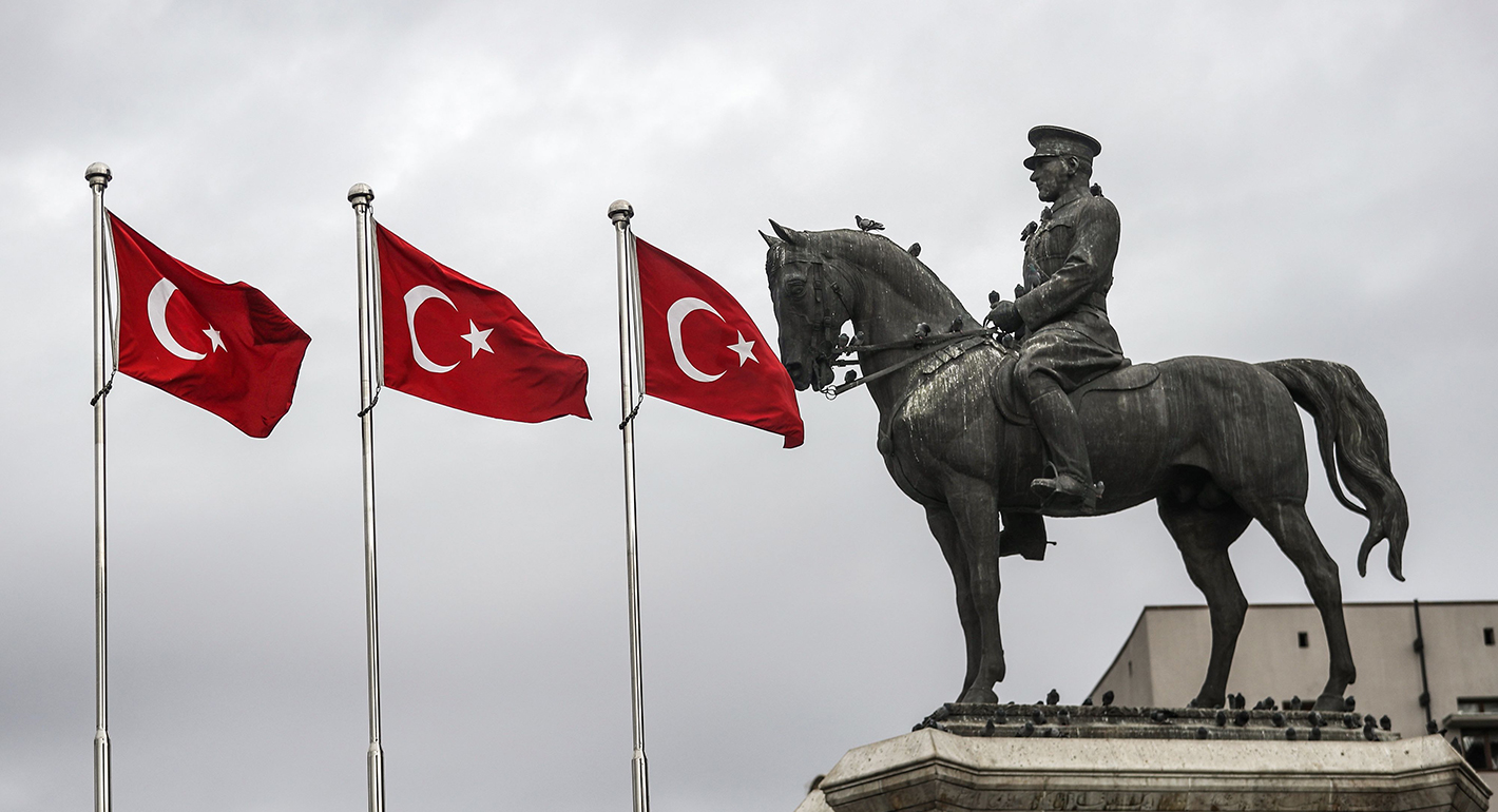 Turkish flags by a statue