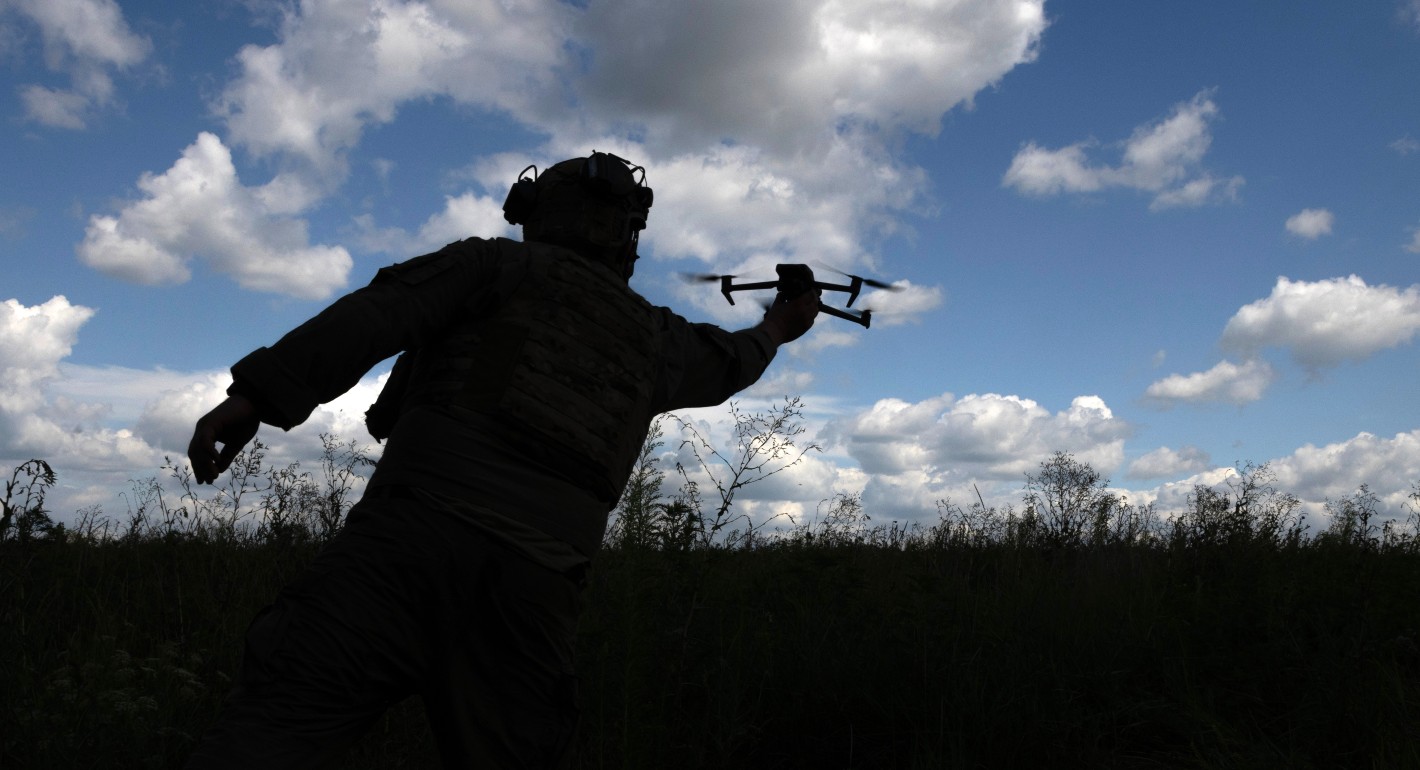 A shadow man holds a shadow drone against a blue sky with clouds.