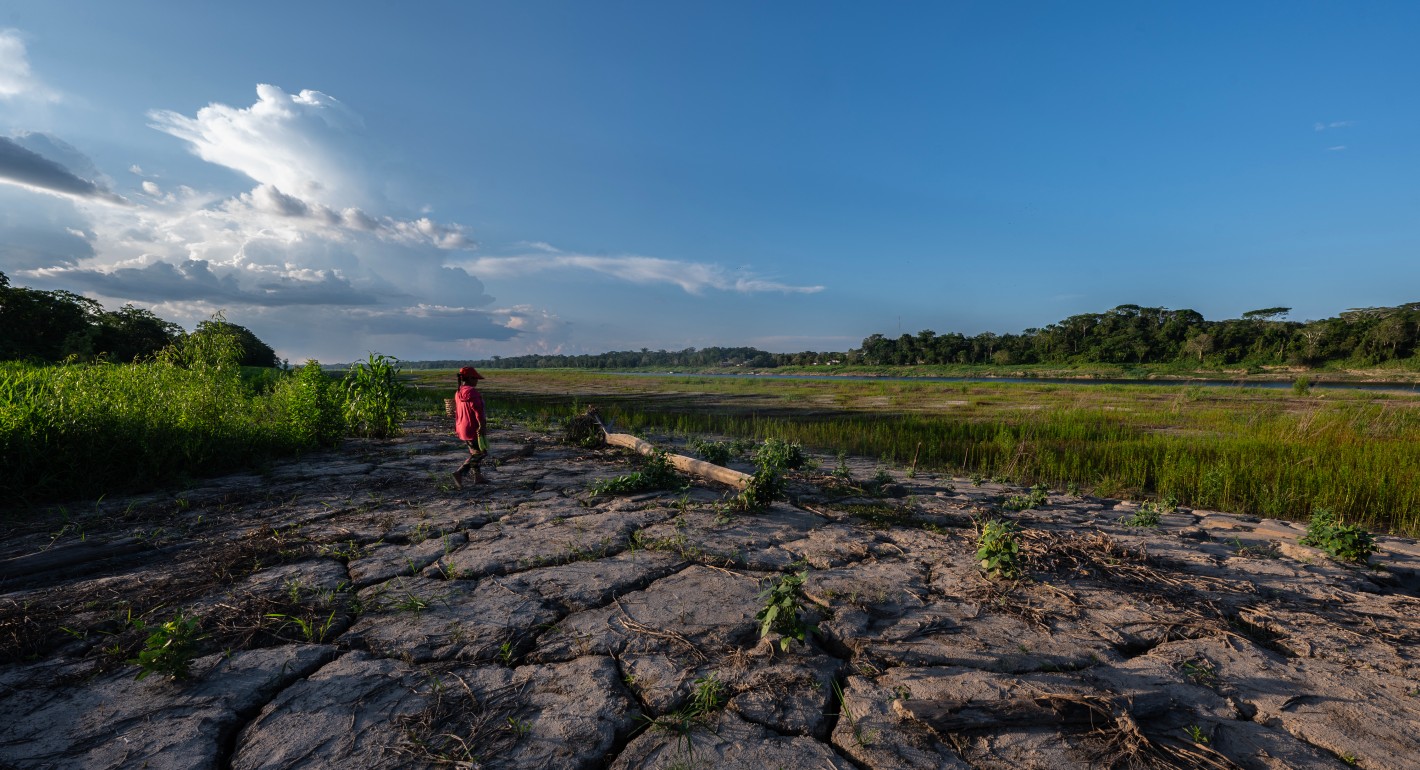 Woman walking on dry, cracked land
