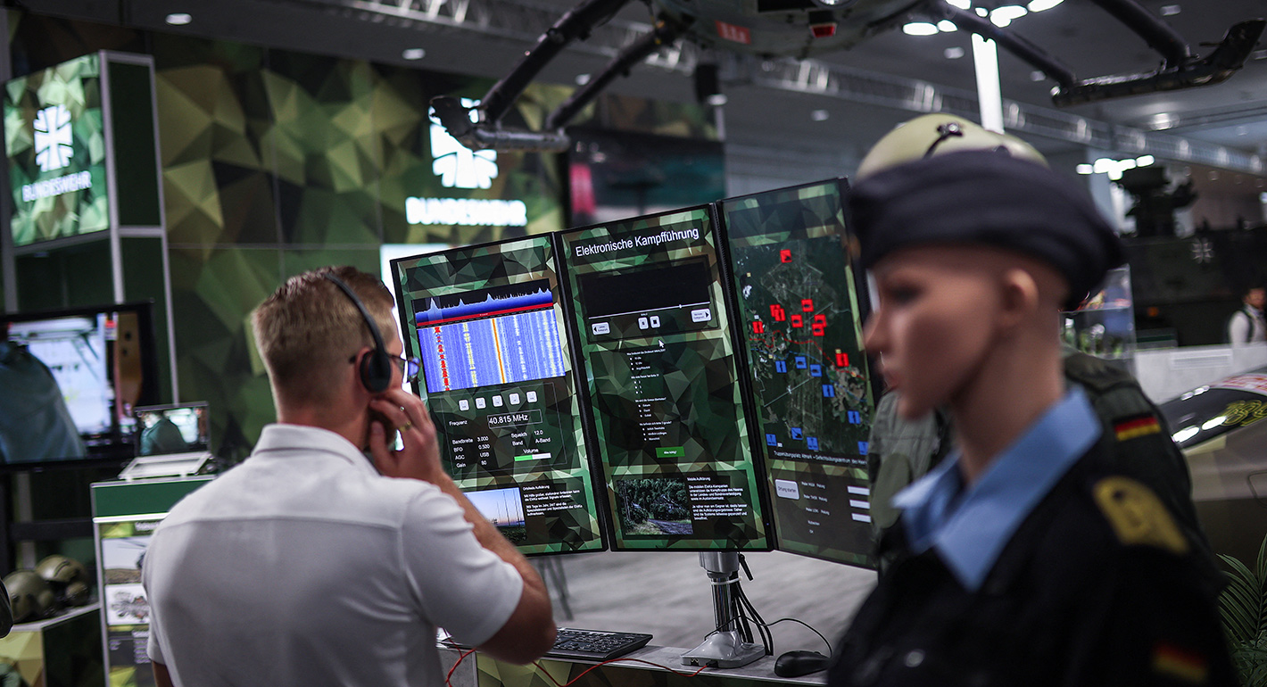 A visitor looks at a simulator for "electronic warfare" at the booth of German Federal Armed Forces Bundeswehr during a tour of the Hannover industrial trade fair for mechanical and electrical engineering and digital industries, in Hannover, northern Germany on April 20, 2026.