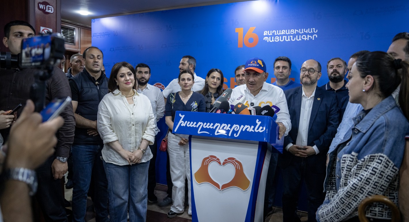 Pashinyan surrounded by supporters while speaking to reporters