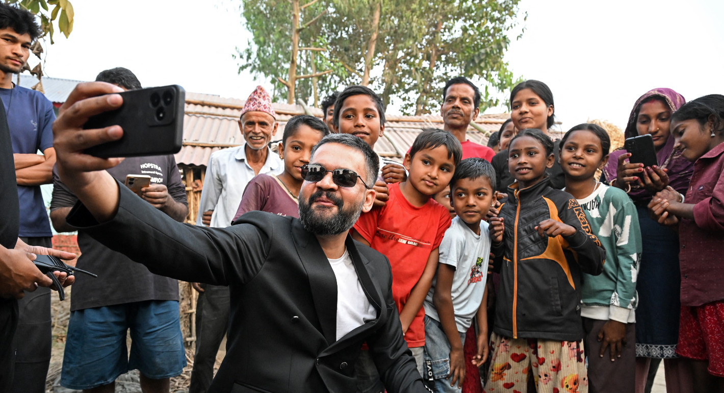 Photo of Balen Shah taking a selfie with a group of Nepali adults and children.