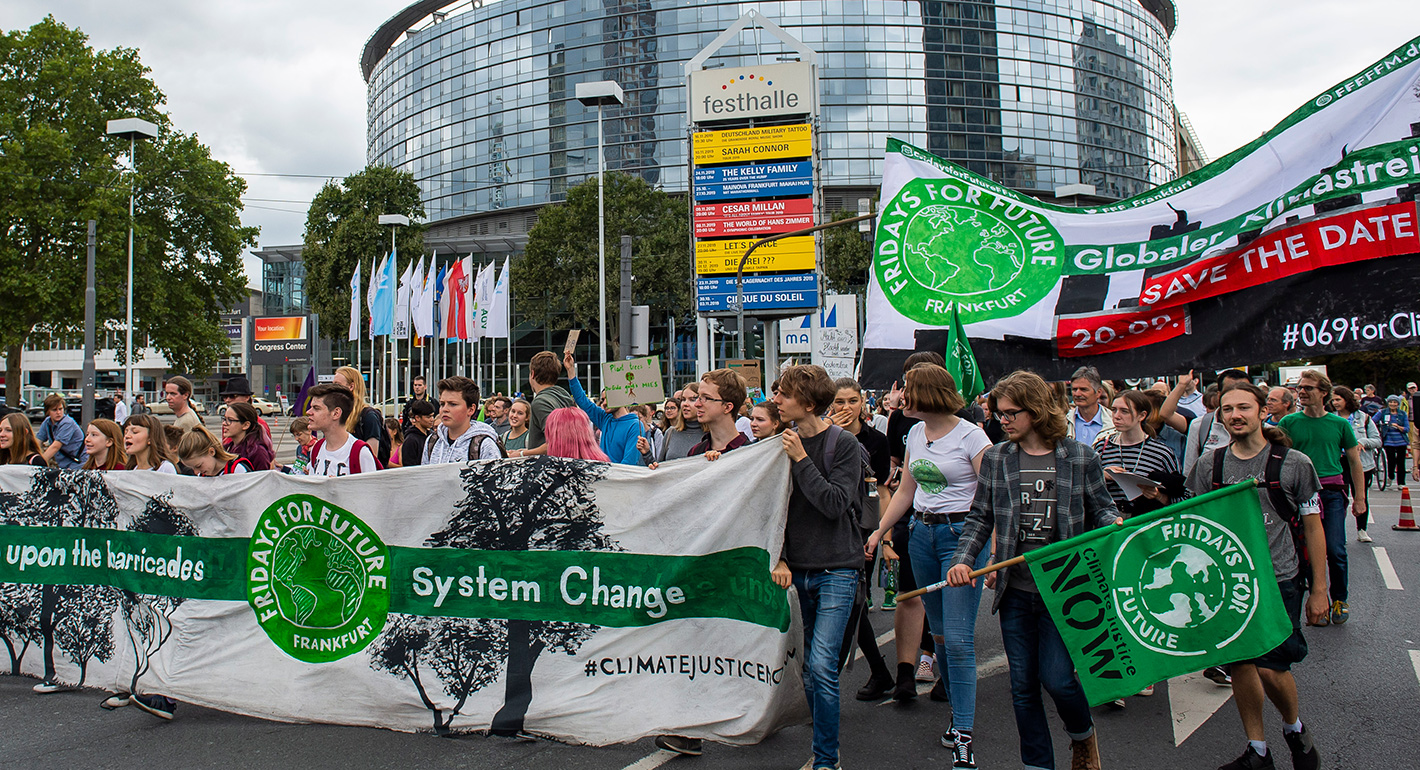 Participants of a Fridays for Future demonstration walk through Frankfurt with protest signs and banners.