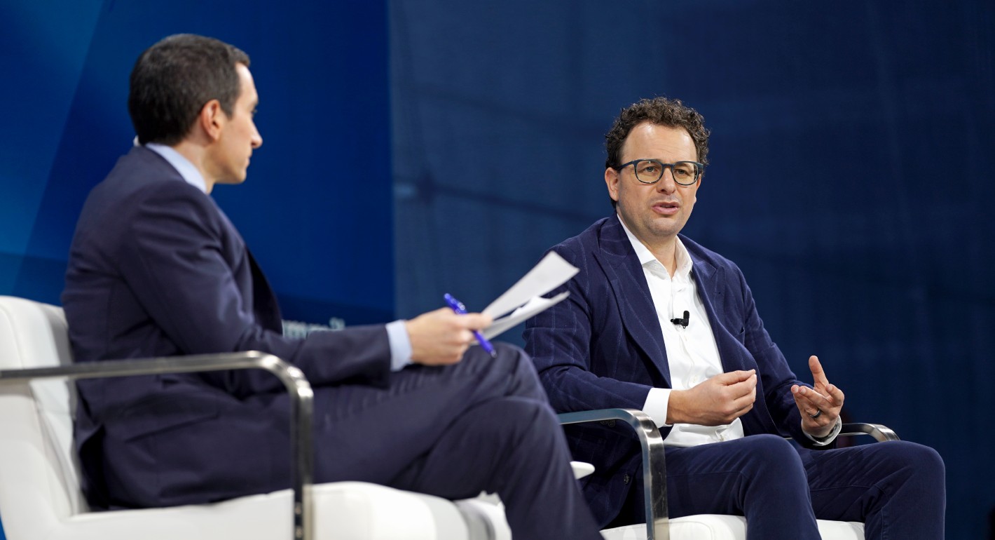 Two men sitting on a stage and speaking