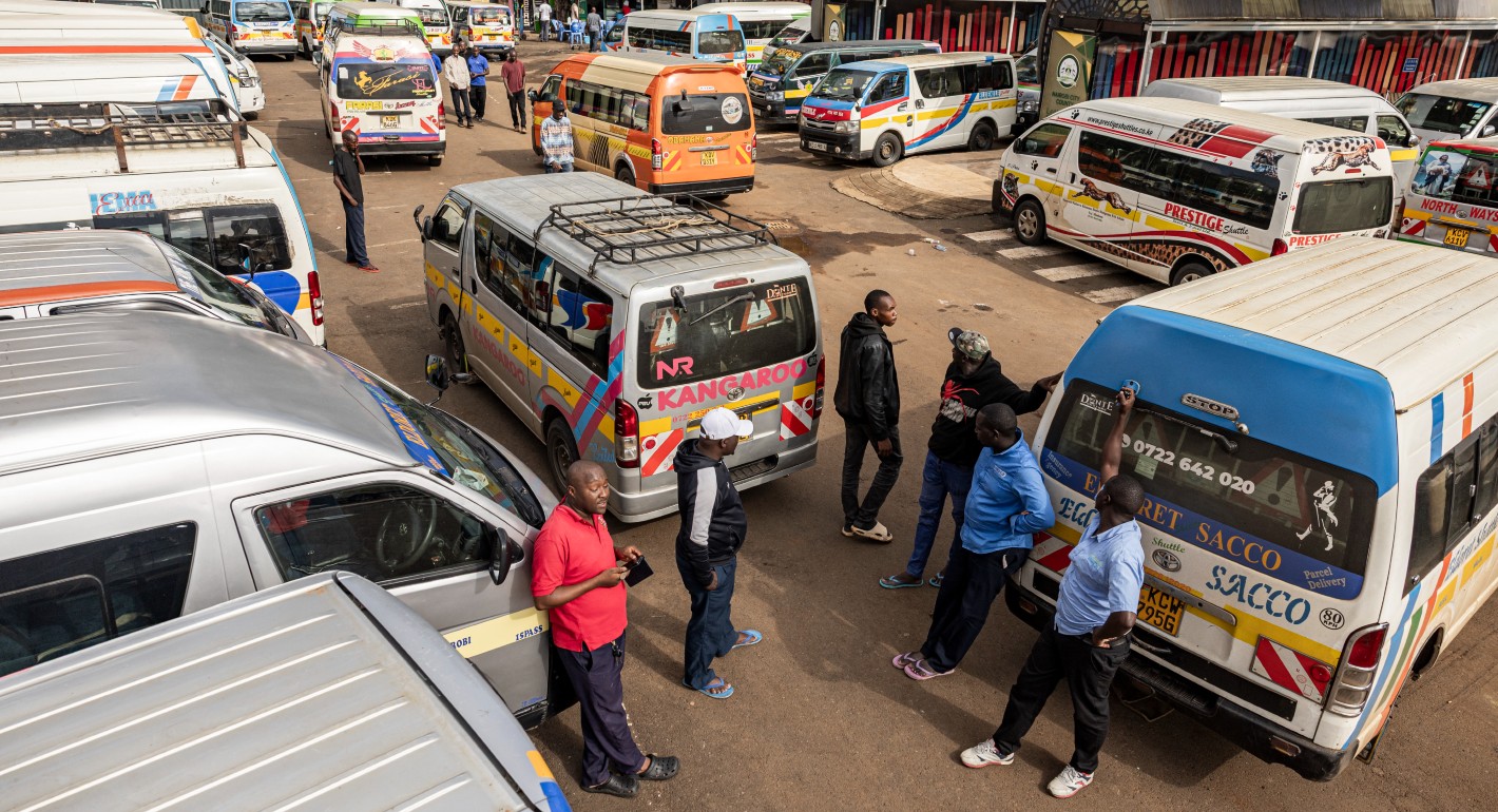 People gathered in a parking lot of buses