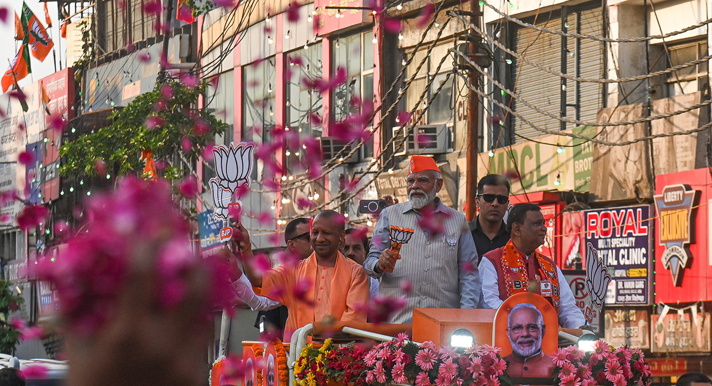 Indian Prime Minister Narendra Modi, wearing an orange cap, and the Chief Minister of Uttar Pradesh, Yogi Adityanath, dressed in saffron robes, are greeting supporters of the Bharatiya Janata Party (BJP) during a roadshow ahead of the Indian General Elections in Ghaziabad, Uttar Pradesh, India, on April 6, 2024.