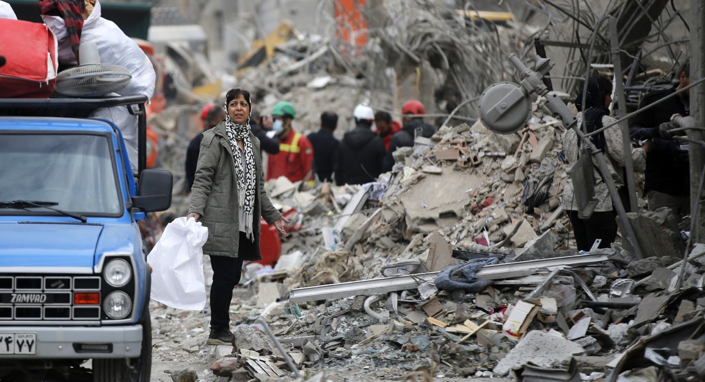 Woman standing amid debris from buildings