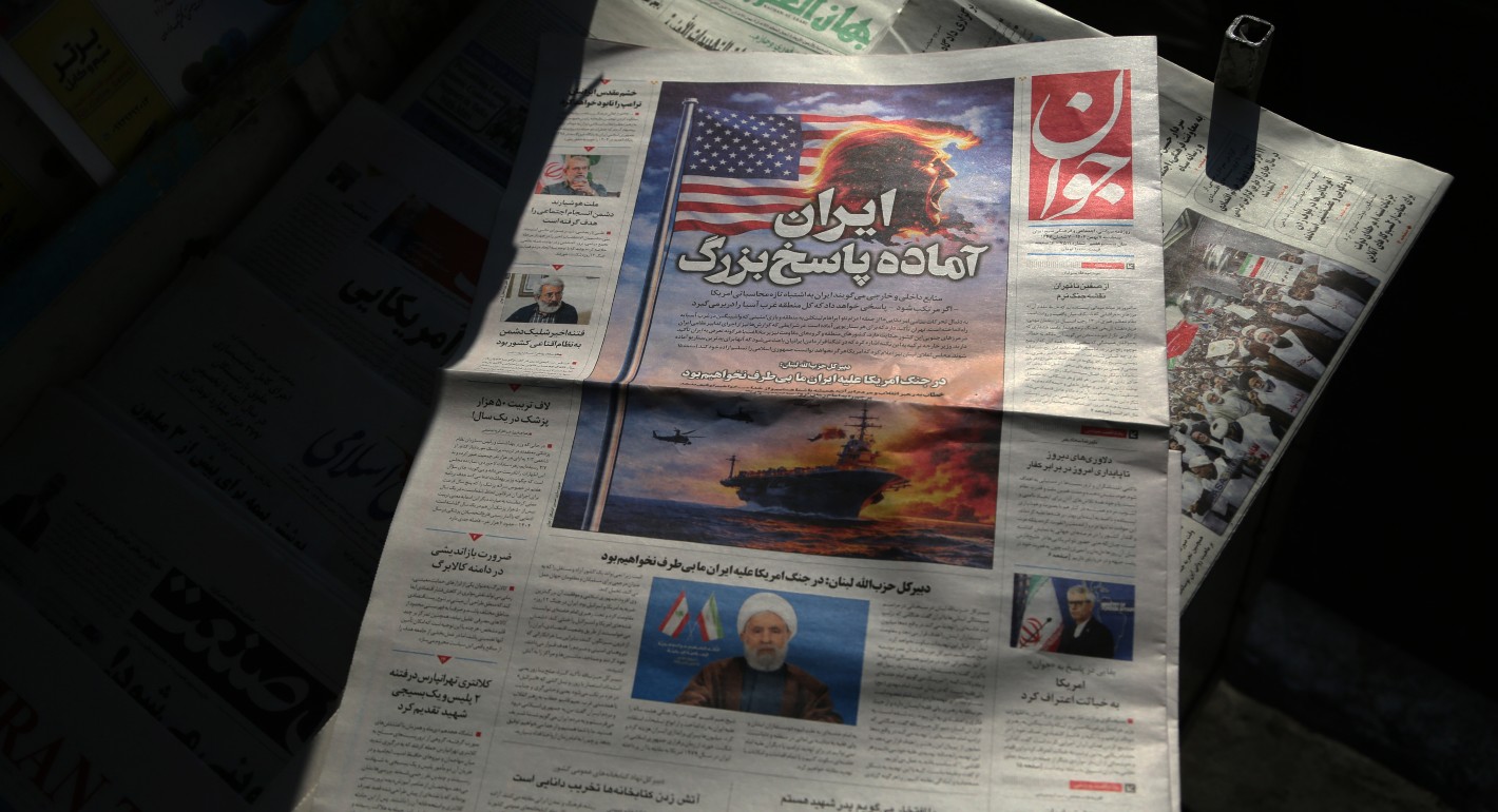 Stack of Iranian newspapers featuring Trump's face and a burning American flag
