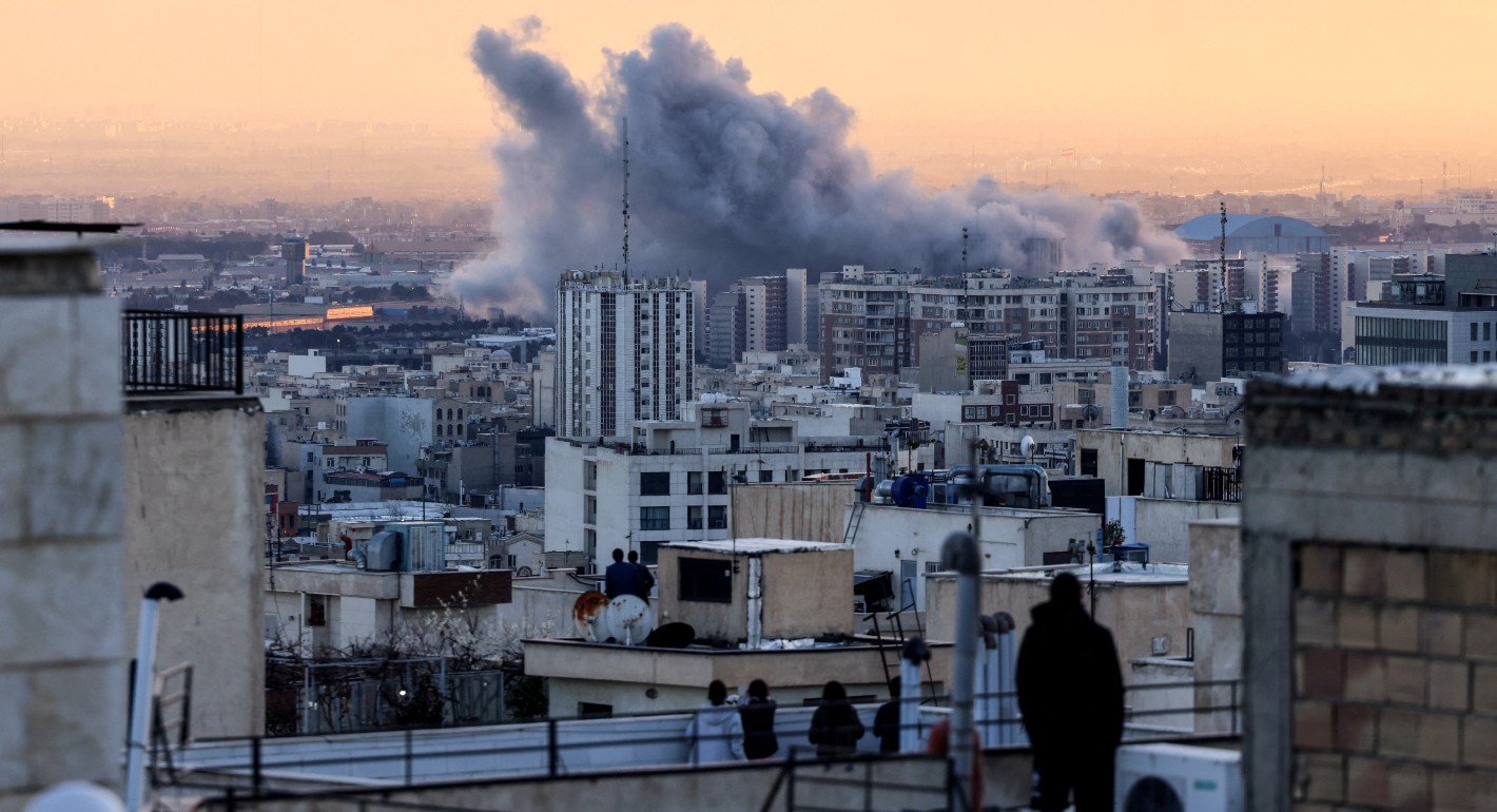 people watching smoke rising at sunrise from rooftops