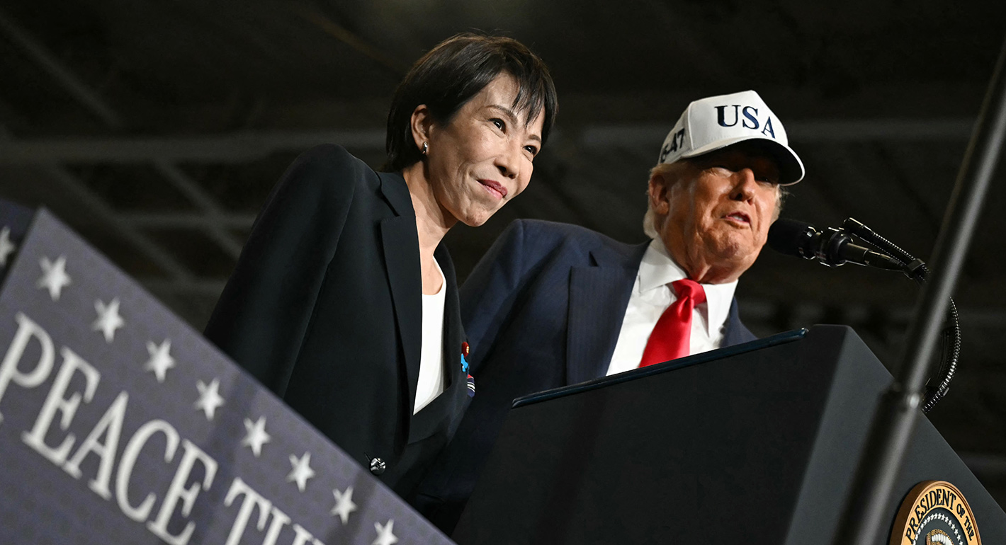 apan's Prime Minister Sanae Takaichi (L) reacts as US President Donald Trump delivers a speech in front of US Navy personnel on board the US Navy's USS George Washington aircraft carrier at the US naval base in Yokosuka on October 28, 2025.