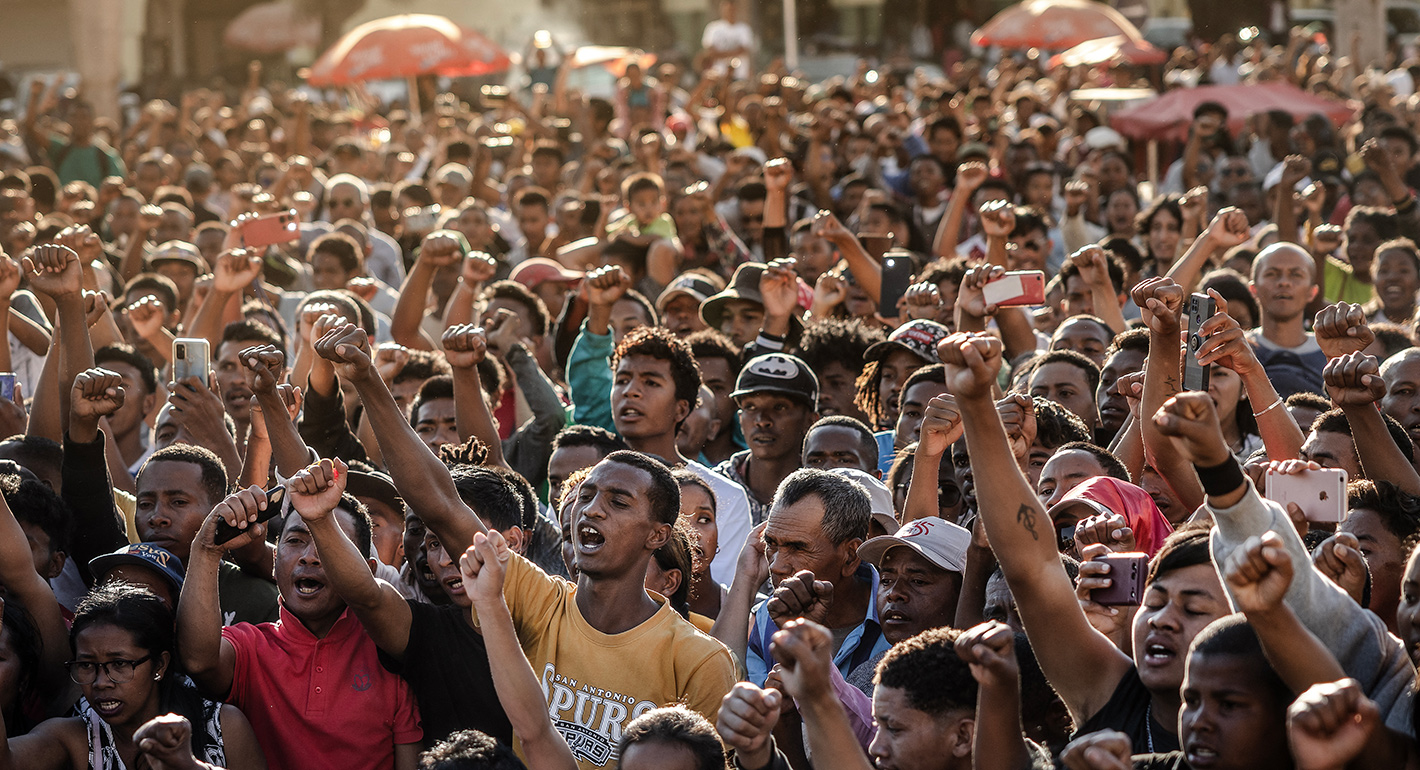 Residents and protesters chant national songs and raise their fists as they gather for a civil society rally demanding the resignation of President Andry Rajoelina and paying tribute to the victims of the protests in Antananarivo, on October 13, 2025