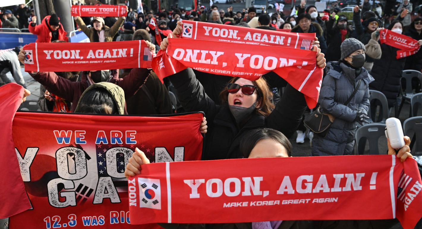 People yelling and holding Yoon Again banners