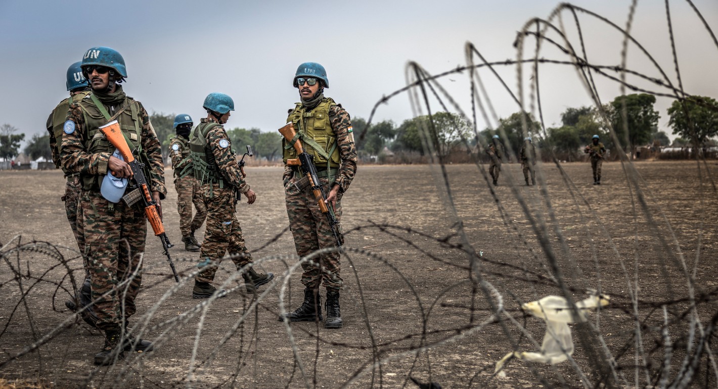 Soldiers standing behind barbed wire