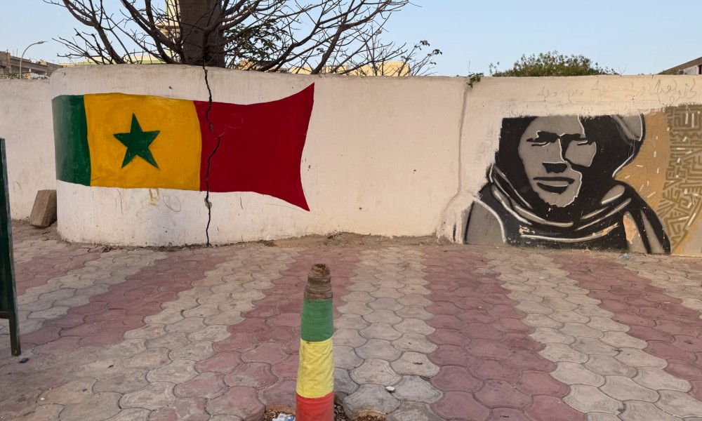 A wall with a flag and a portrait