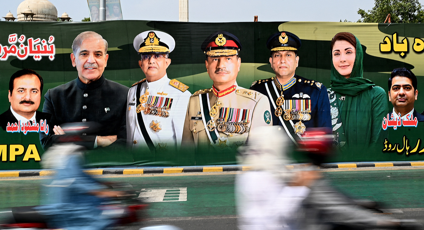 Commuters ride past a billboard with portraits of Pakistan's Prime Minister Shehbaz Sharif (2L), Navy Chief Admiral Naveed Ashraf (3L), Chief of Army Staff General Syed Asim Munir (C), Air Chief Marshal Zaheer Ahmad Baber (3R) and Chief Minister of the country's Punjab province Maryam Nawaz Sharif (2R), displayed along a street in Lahore on May 24, 2025. 