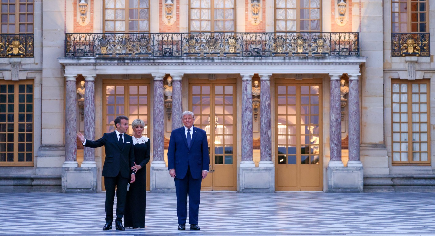 Three people standing outside a fancy building