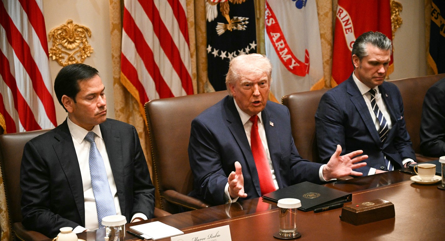 Trump seated and gesturing while speaking