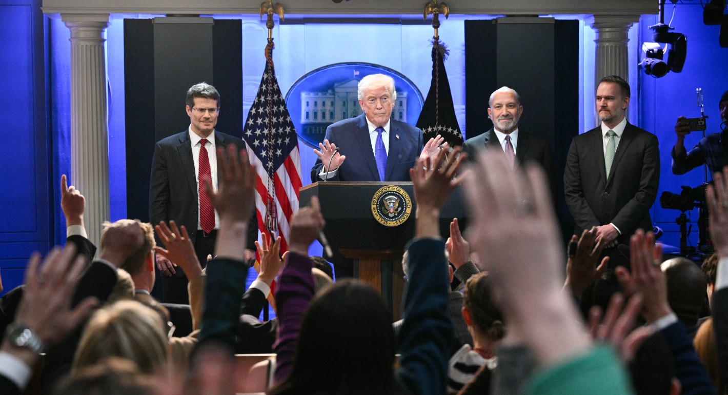 Trump raises hands behind a lectern