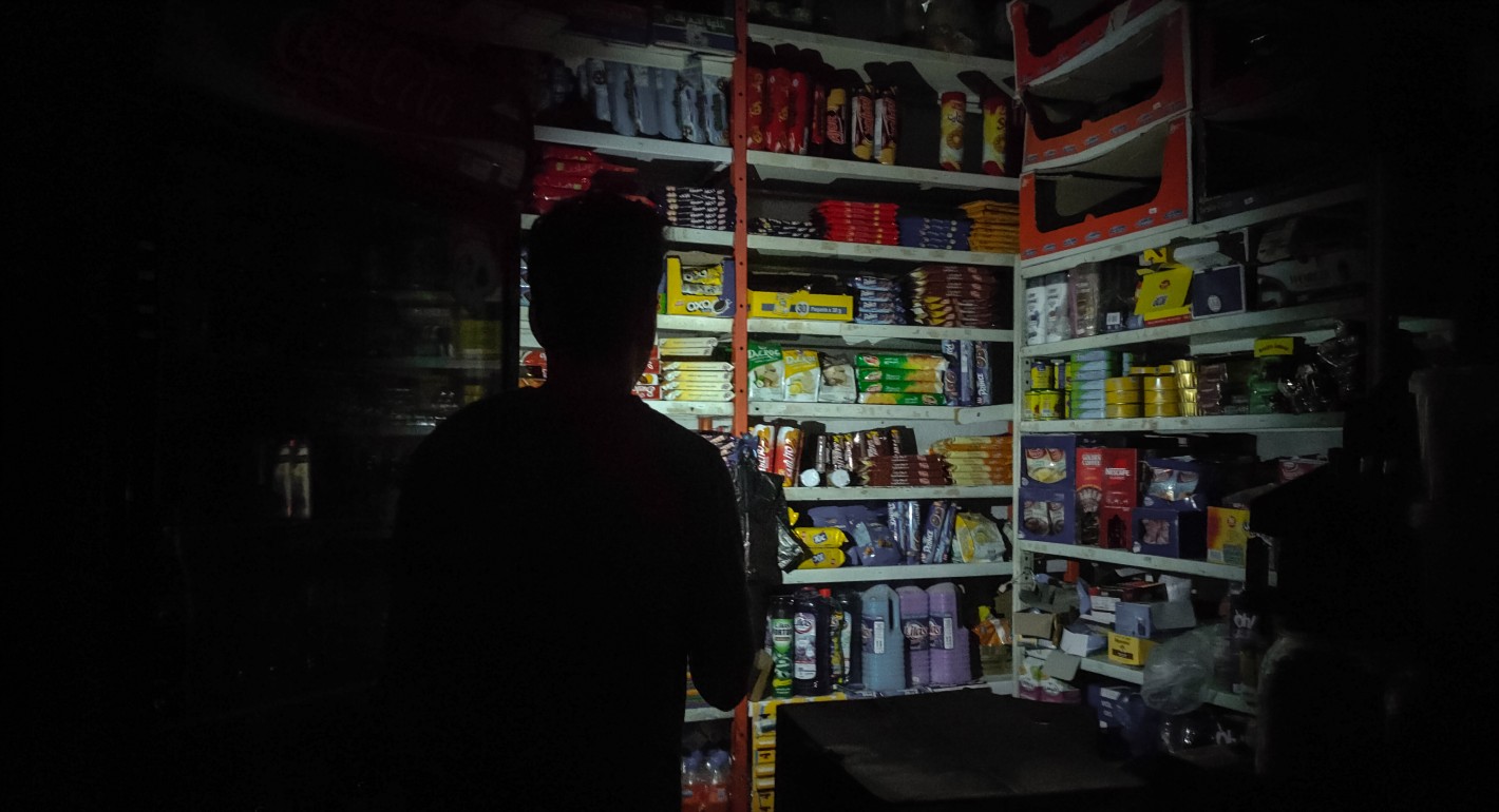Shadowed figure lighting grocery store shelves