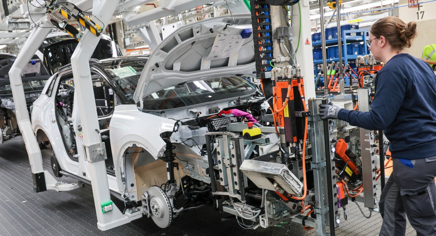 Worker pushing machinery toward a car frame