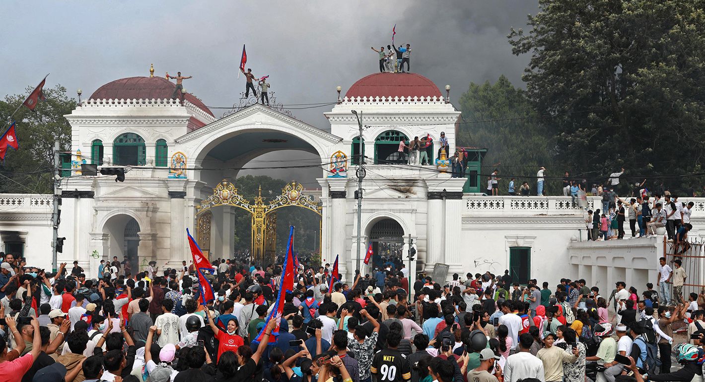 Protesters gather at the Singha Durbar, the main administrative building for the Nepal government, in Kathmandu on September 9, 2025, a day after a police crackdown on demonstrations over social media prohibitions and corruption by the government. Nepali youth protesters set fire to parliament on September 9 as the veteran prime minister obeyed furious crowds to quit, a day after one of the deadliest crackdowns in years in which at least 19 people were killed