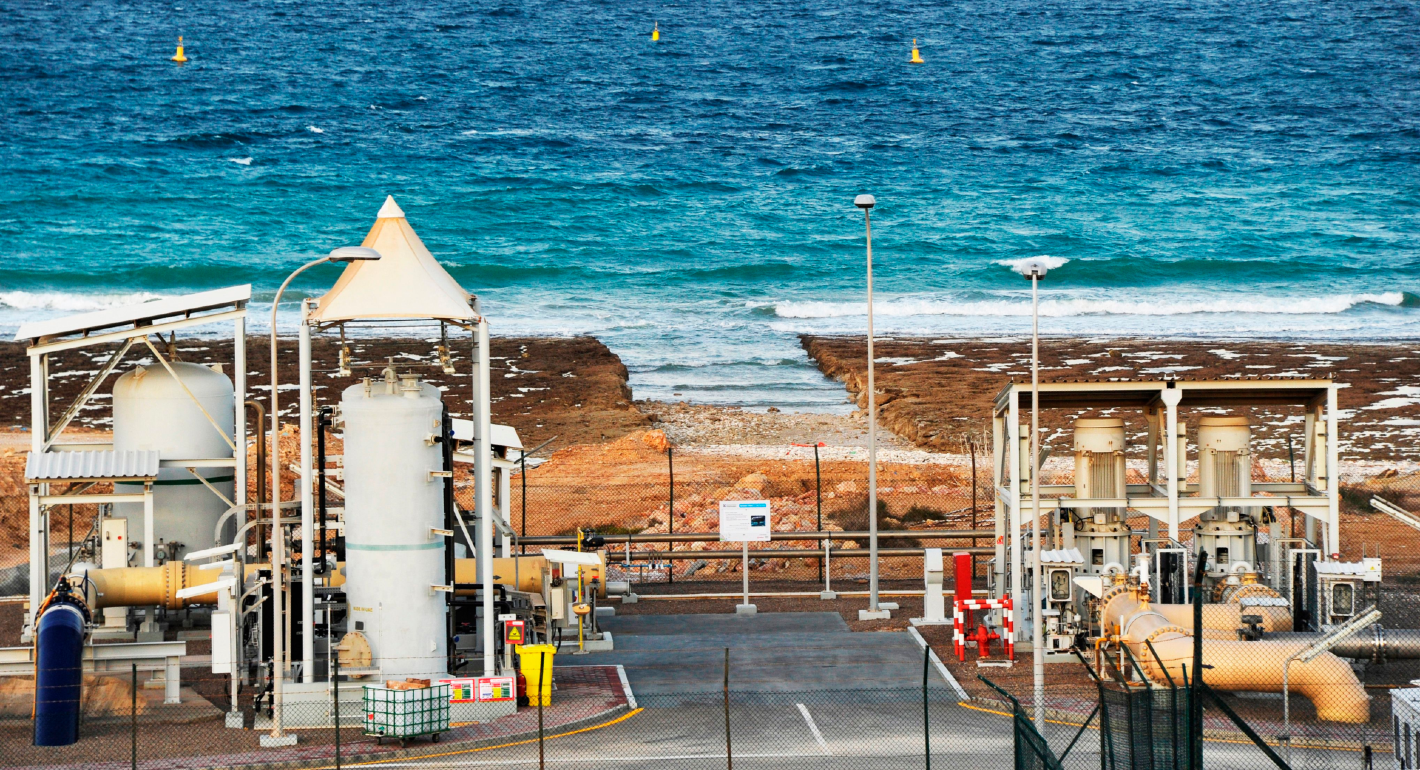 Photo of a desalination plant against the ocean.