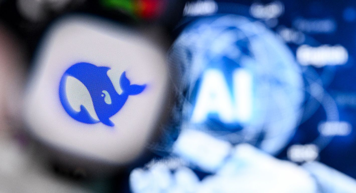 A photo taken on April 1, 2025 shows AI letters on a laptop screen (R) next to the logo of Deepseek AI application on a smartphone screen in Frankfurt am Main, western Germany.