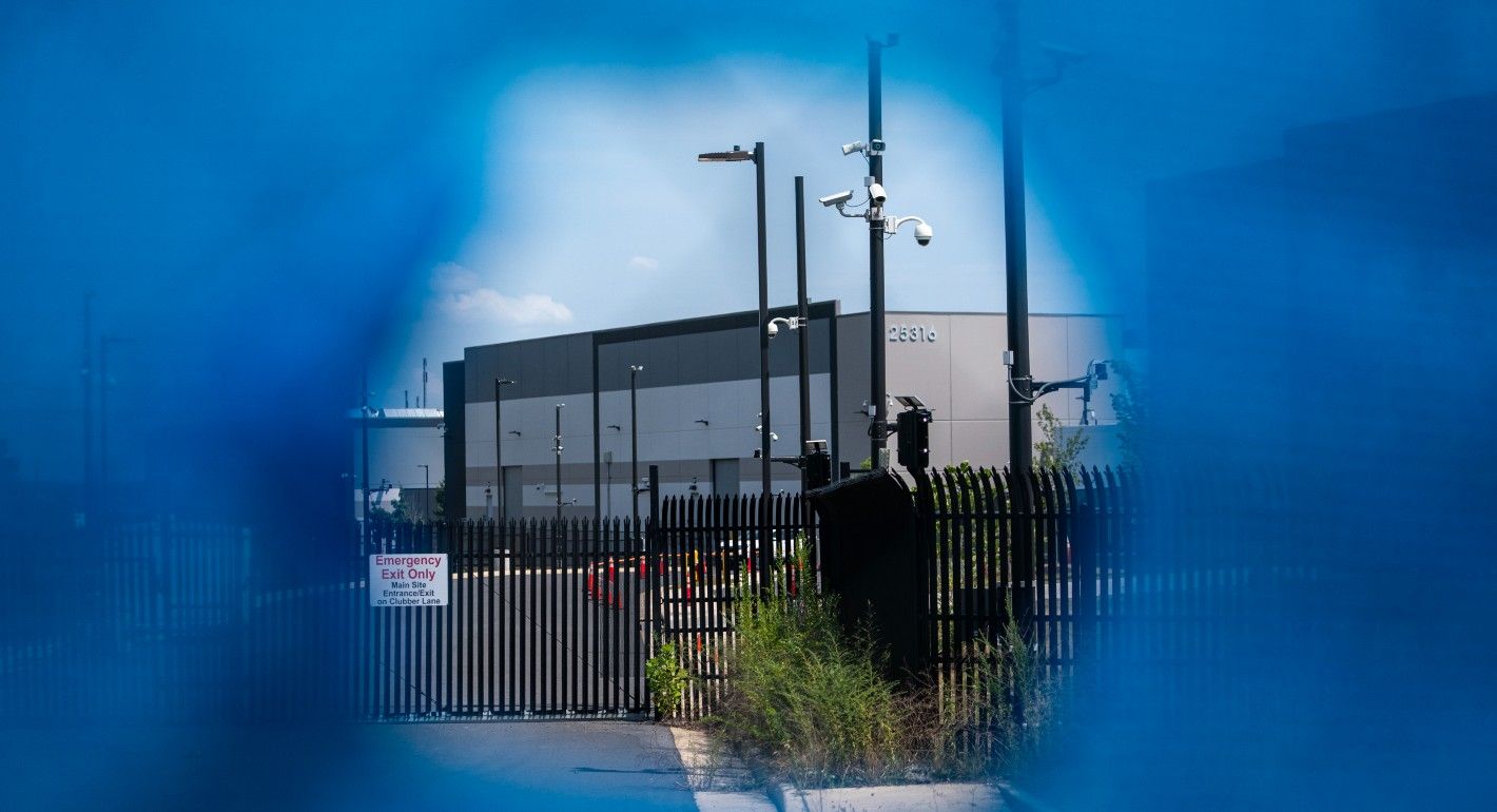 Large building with security cameras and fences around it