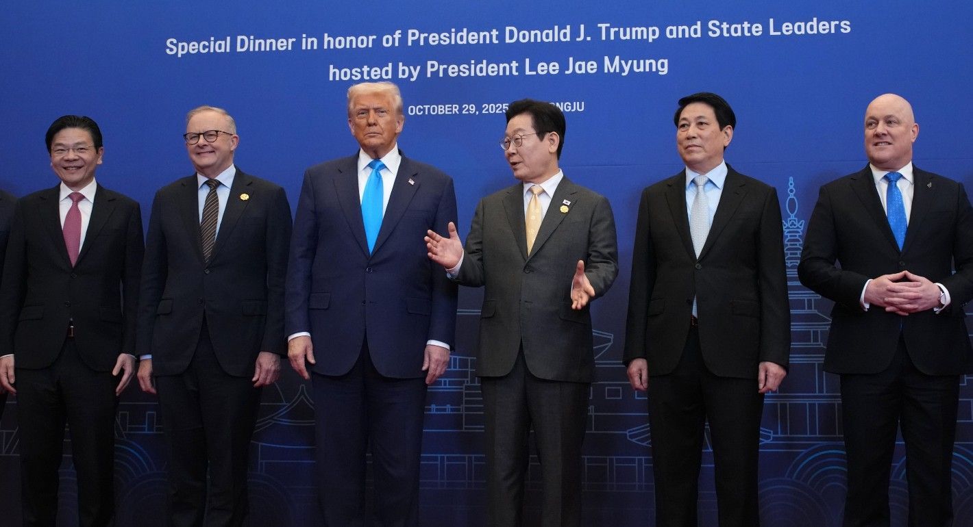 Men standing in a line against a blue background