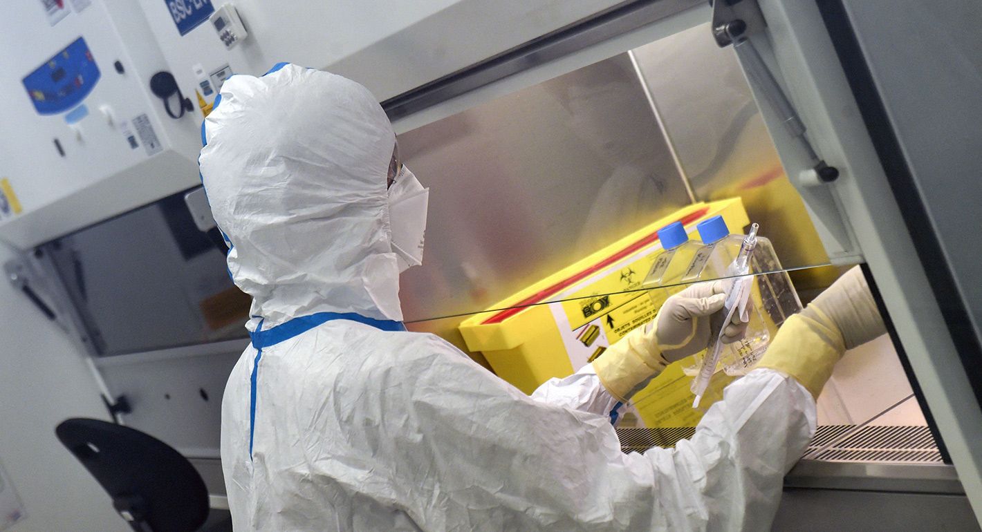 French engineer-virologist Thomas Mollet divides a 40ml flask, infected with a Sars-CoV-2 virus, under a laminar flow at the Biosafety level 3 laboratory (BSL3) of the Valneva SE Group headquarters in Saint-Herblain, near Nantes, western France, on July 30, 2020.