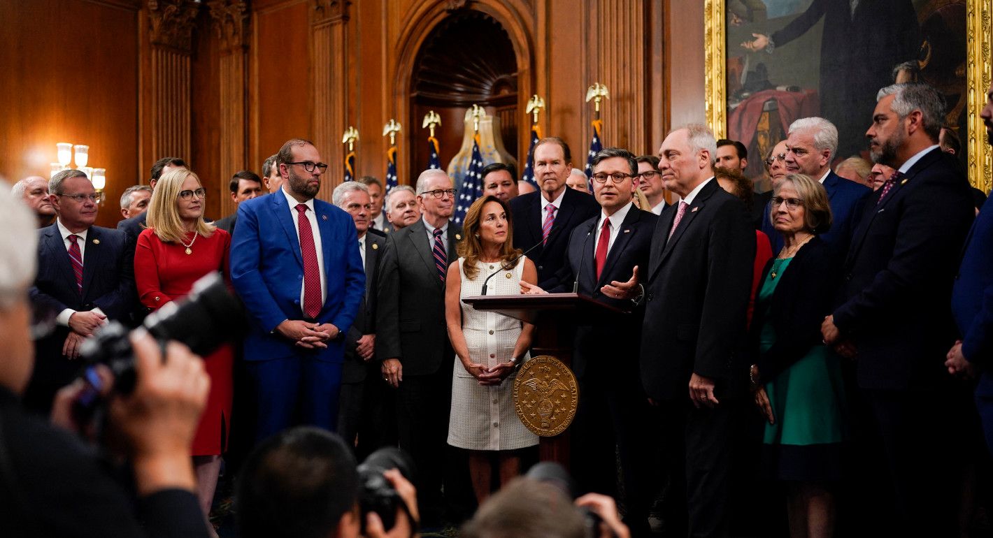 Mike Johnson surrounded by lawmakers while speaking to the press