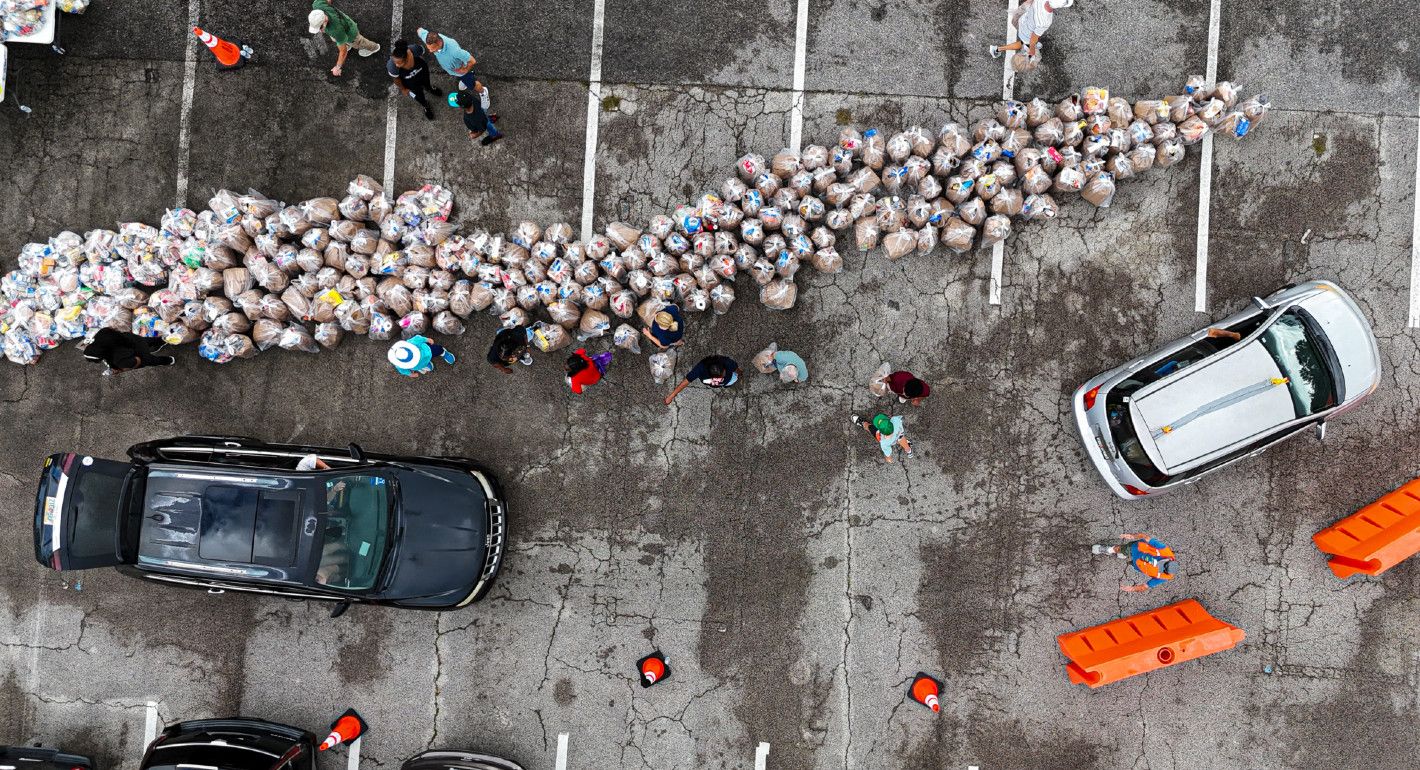 Photo of bags of groceries being distributed to SNAP recipients in a parking lot.