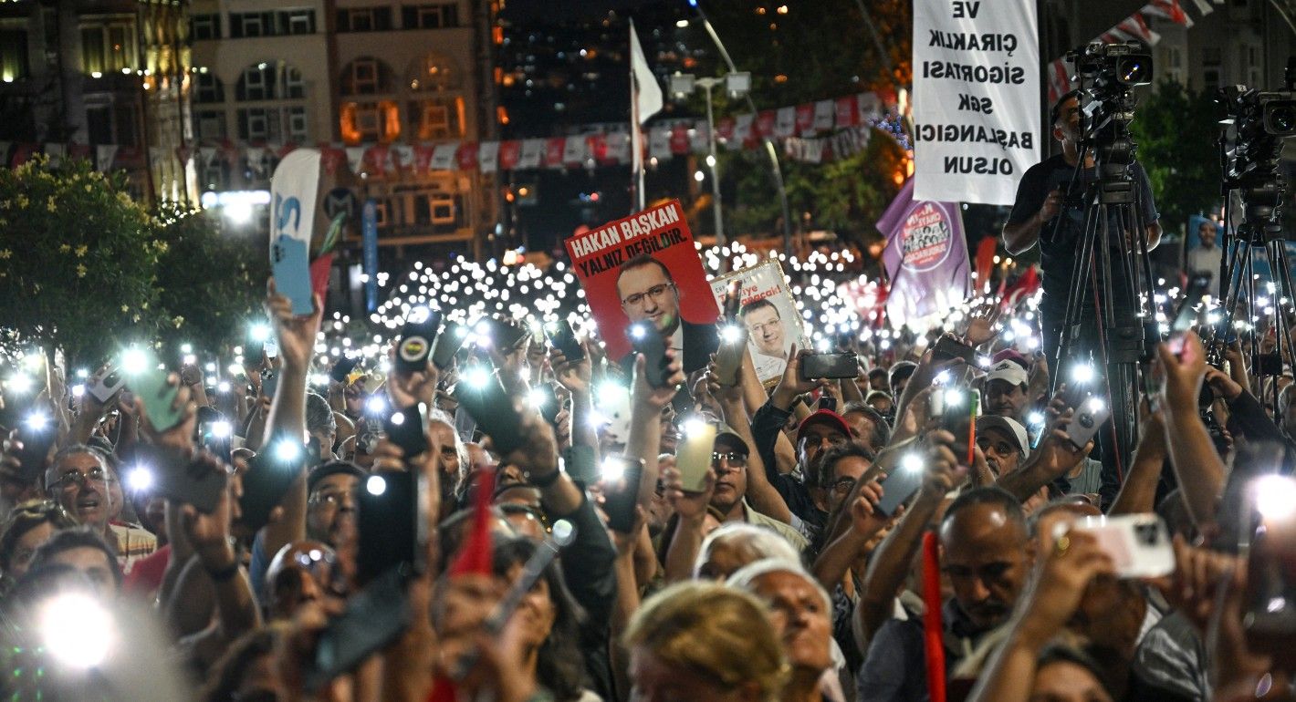 Crowd of people holding up their mobile phones with flashlights on