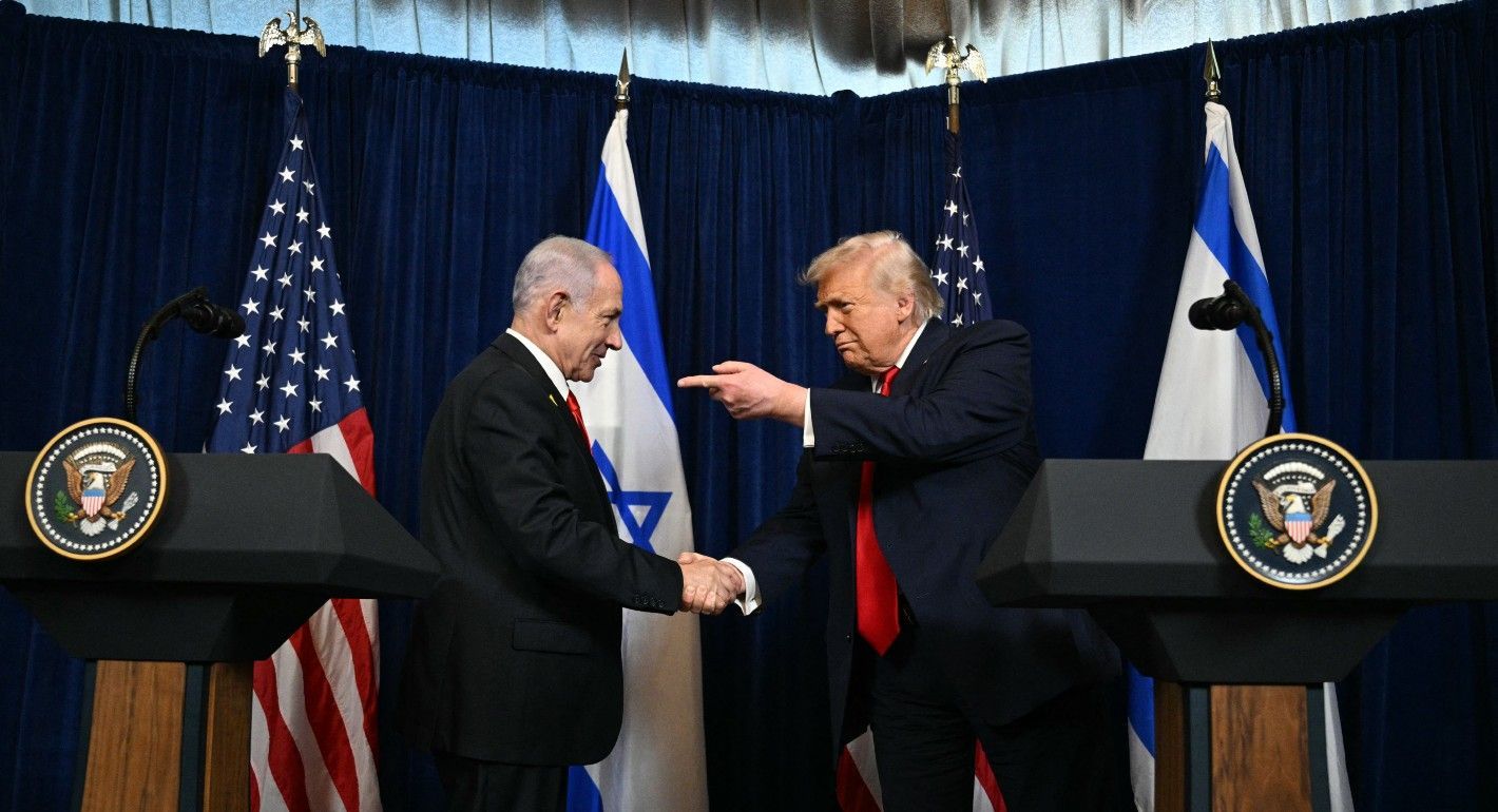 Trump pointing at Netanyahu while the two shake hands