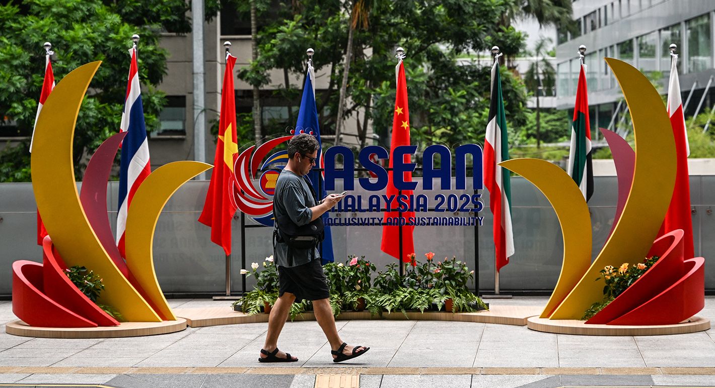 A man walks in front of the logo of the Association of Southeast Asian Nations (ASEAN) ahead of the 46th ASEAN Summit in Kuala Lumpur on May 25, 2025