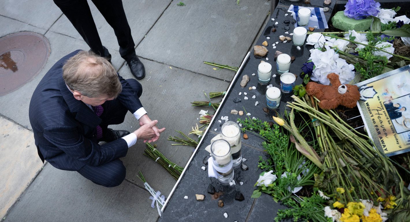 Overhead shot of a man kneeling next to flowers and candles